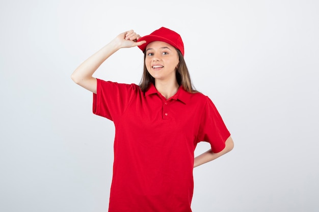 jeune courrier féminin en uniforme rouge se sentant heureux.