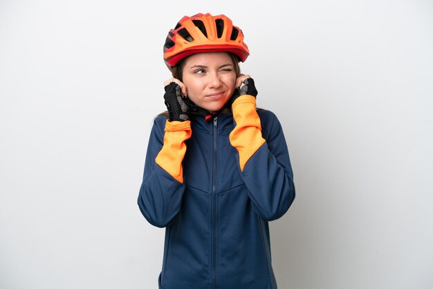 Jeune cycliste lituanienne femme isolée sur fond blanc frustré et couvrant les oreilles