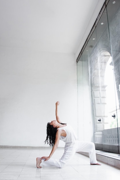 Jeune danseur posant dans un studio blanc