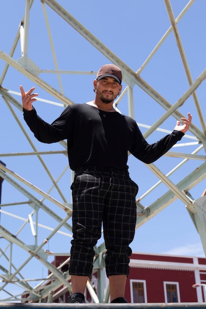 Jeune danseur de rue latino hispanique avec fond de ciel bleu et structure métallique