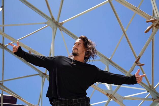 Jeune danseur de rue latino hispanique avec fond de ciel bleu et structure métallique