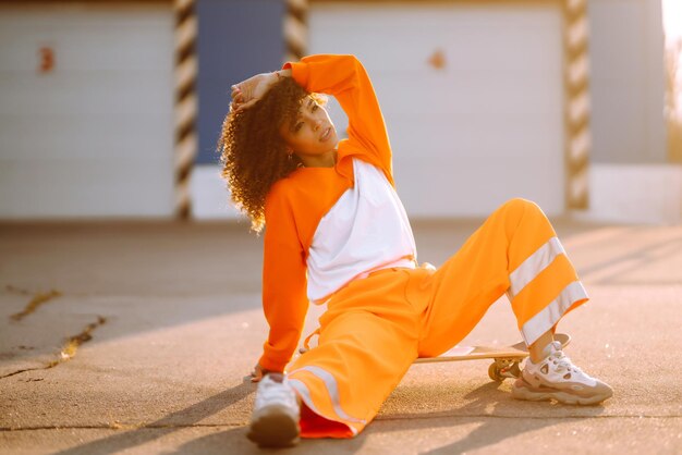 Une jeune danseuse afro-américaine dansant dans la rue au coucher du soleil Une femme élégante aux cheveux bouclés