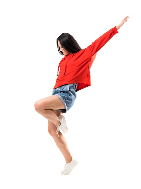 Jeune danseuse asiatique sur mur blanc isolé