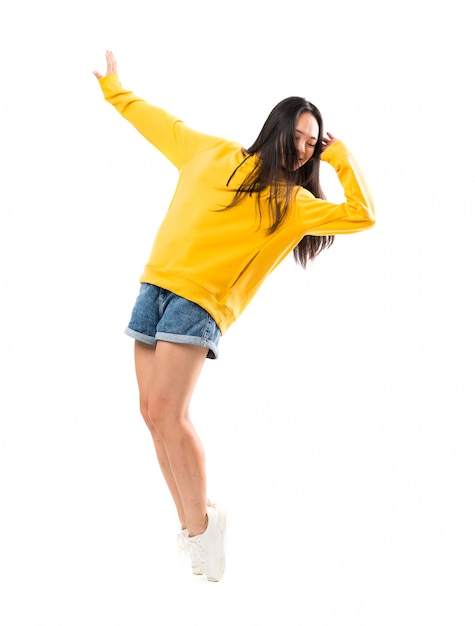 Jeune danseuse asiatique sur mur blanc isolé