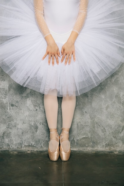 Jeune danseuse de ballerine dansant le ballet classique contre un mur rustique