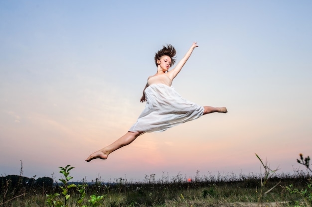 Jeune danseuse de ballet se produit en plein air sur le coucher du soleil