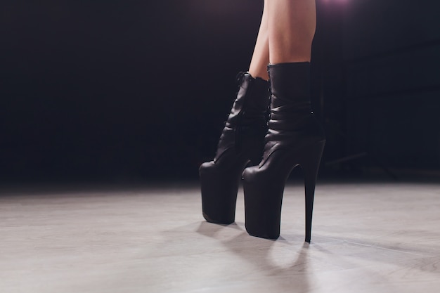 Jeune danseuse de strip-tease se déplaçant en chaussures à talons hauts sur scène en strip night club