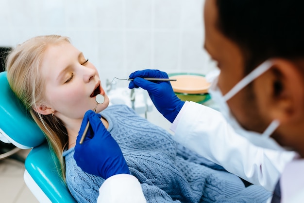 jeune dentiste asiatique confiant Traitement médical d'une patiente à la clinique. Concept de clinique dentaire.