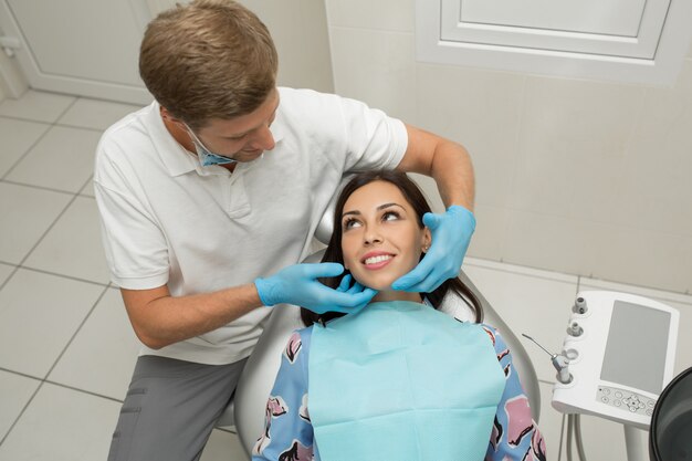 Un jeune dentiste et une patiente heureuse.