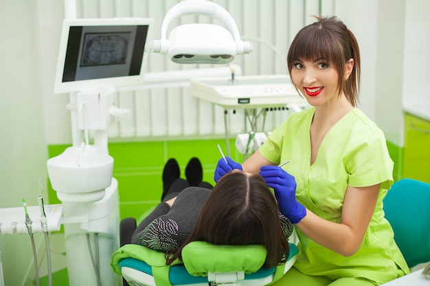 Jeune dentiste traitant une patiente dans le cabinet dentaire