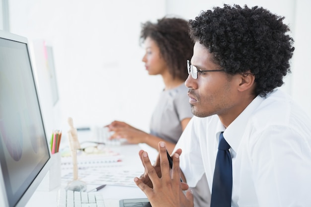 Jeune designer en regardant l&#39;ordinateur à son bureau