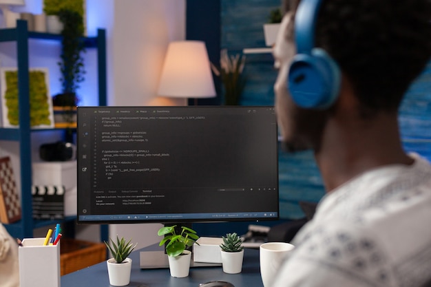 Jeune développeur afro-américain portant un casque tout en tapant des codes de sécurité