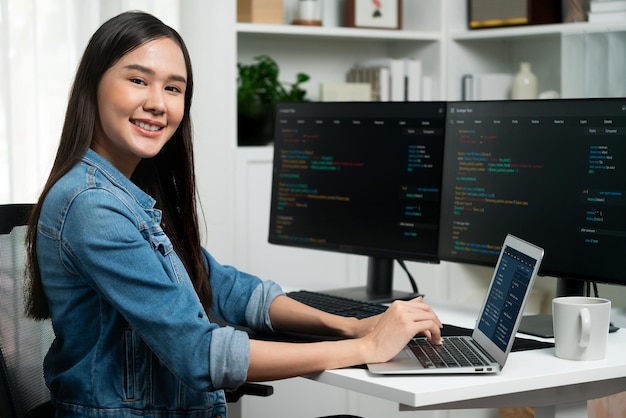 Jeune développeur asiatique en it regardant la caméra pour présenter sur pc stratagem