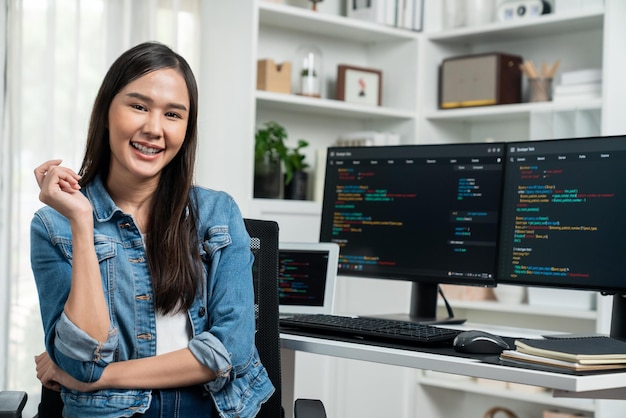 Jeune développeur asiatique en it regardant la caméra pour présenter sur pc stratagem