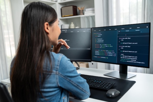 Jeune développeur asiatique à la recherche d'informations en ligne sur PC pour poser un stratagème
