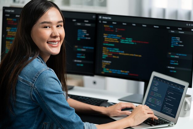 Jeune développeur informatique asiatique regardant la caméra pour présenter sur PC Stratagem