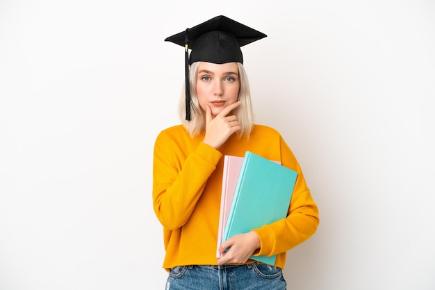 Jeune diplômé universitaire caucasien femme isolé sur fond blanc pensant