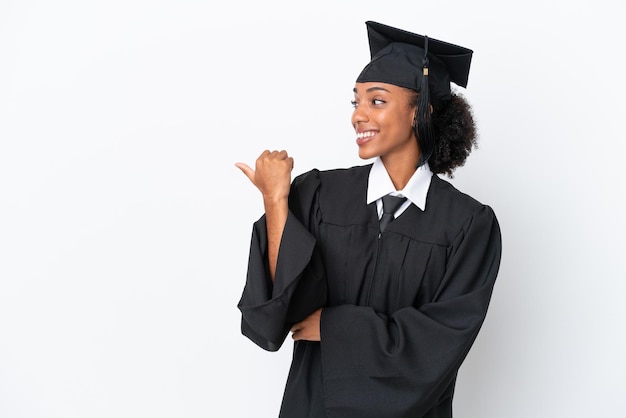 Jeune diplômé universitaire femme afro-américaine isolée sur fond blanc pointant vers le côté pour présenter un produit