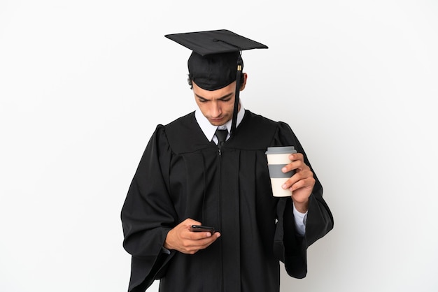 Jeune Diplômé Universitaire Sur Fond Blanc Isolé Tenant Du Café à Emporter Et Un Mobile