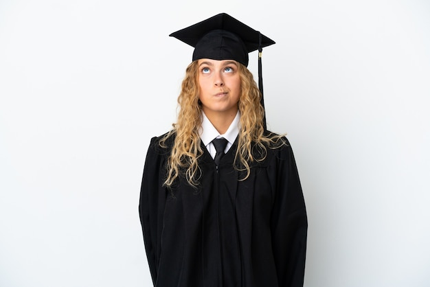 Jeune diplômé universitaire isolé sur fond blanc et levant