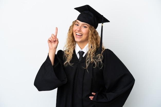 Jeune diplômé universitaire isolé sur fond blanc montrant et levant un doigt en signe du meilleur