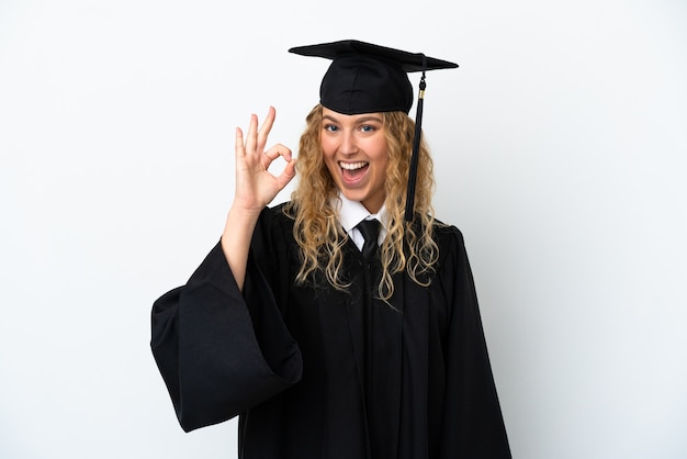 Jeune diplômé universitaire isolé sur fond blanc montrant signe ok avec les doigts