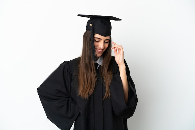 Jeune diplômé universitaire isolé sur fond blanc en riant