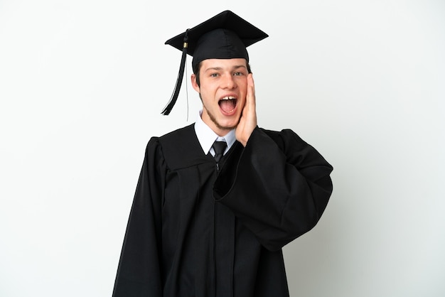 Jeune diplômé universitaire russe isolé sur fond blanc avec une expression faciale surprise et choquée