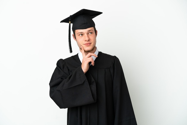 Jeune diplômé universitaire russe isolé sur fond blanc pensant une idée tout en levant les yeux