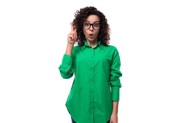 Photo jeune dirigeante brune intelligente et réussie vêtue d'une chemise verte sur un fond blanc