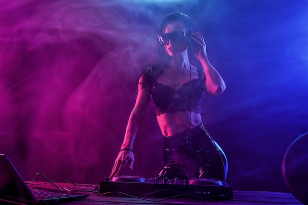 Jeune DJ sexy avec des lunettes de soleil jouant de la musique