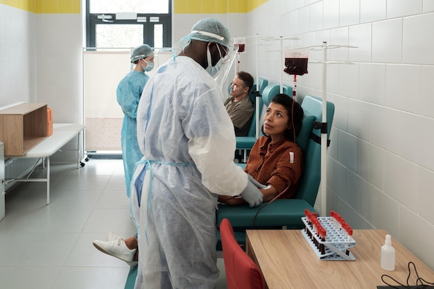 Jeune donneuse hispanique regardant un clinicien afro-américain