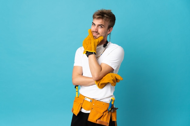 Jeune électricien homme isolé mur souriant