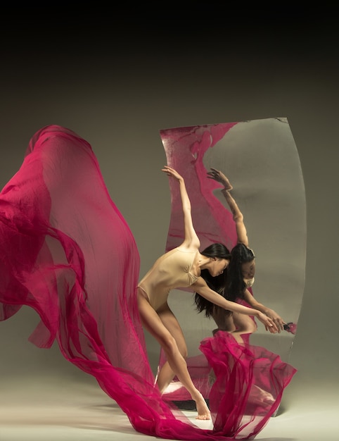 Jeune et élégant danseur de ballet moderne devant un miroir