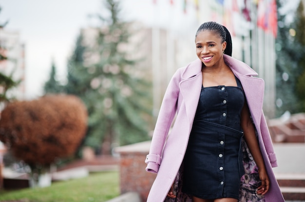 Jeune élégante belle femme afro-américaine dans la rue, portant un manteau de tenue de mode.