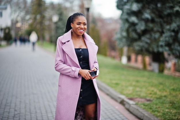 Jeune élégante belle femme afro-américaine dans la rue portant un manteau de tenue de mode