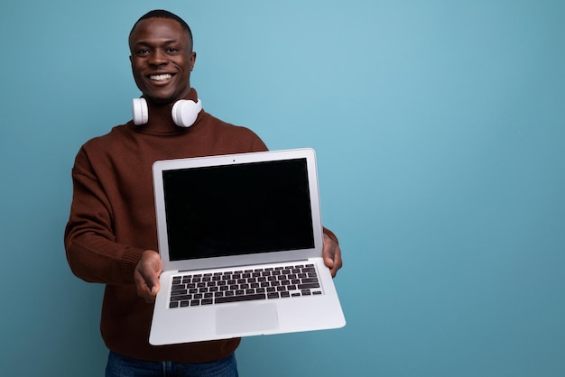 Un jeune employé de bureau africain montre un projet de travail à l'aide d'un ordinateur portable