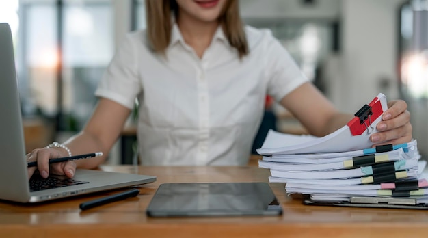 Jeune employé de bureau travaillant avec des documents et un ordinateur portable à table