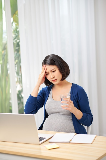 Jeune employée enceinte travaillant au bureau