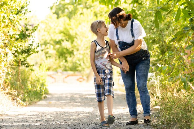 Jeune et enceinte mère avec son fils dans le parc d'été