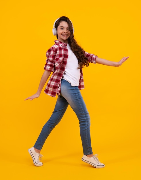 Jeune enfant adolescent écoutant de la musique avec un casque Fille écoutant des chansons via un casque sans fil Accessoire pour casque sans fil Heureux adolescent émotions positives et souriantes d'une adolescente