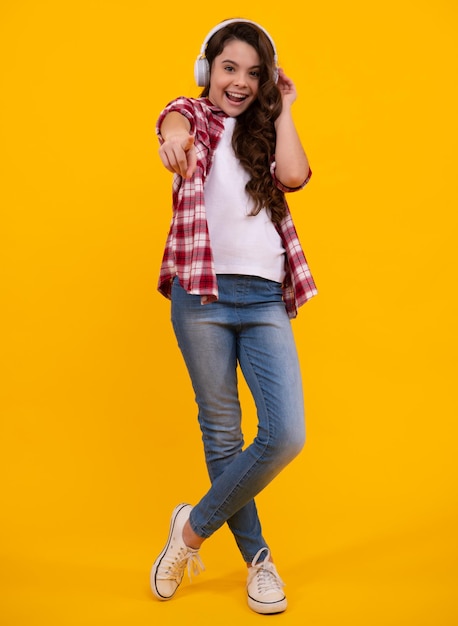 Jeune enfant adolescent écoutant de la musique avec un casque Fille écoutant des chansons via un casque sans fil Accessoire pour casque sans fil Heureux adolescent émotions positives et souriantes d'une adolescente