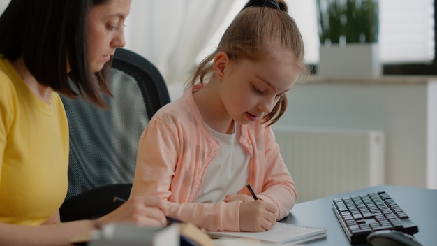 Jeune Enfant écrit Ses Devoirs Sur Un Ordinateur Portable Et Aide Sa Mère