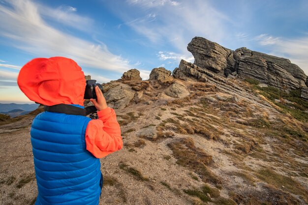 Jeune enfant garçon randonneur prendre des photos dans les montagnes en appréciant la vue sur le magnifique paysage de montagne
