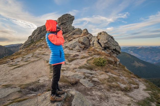 Jeune enfant garçon randonneur prendre des photos dans les montagnes