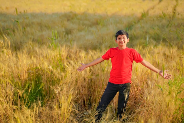 Jeune enfant indien jouant au champ de blé