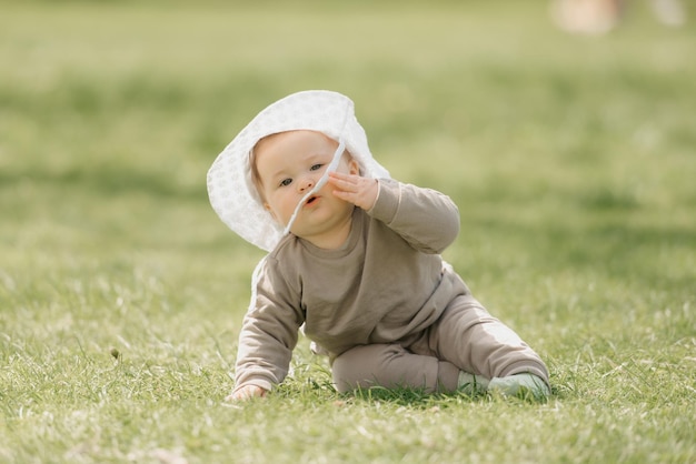 Un jeune enfant mois dans le chapeau panama s'amuse dans le pré