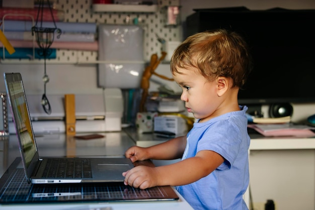 Un jeune enfant regarde des vidéos sur un ordinateur portable