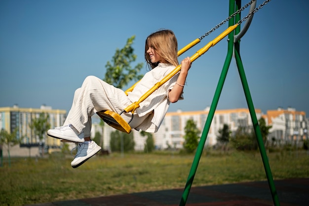 Jeune enfant s'amusant sur l'aire de jeux en plein air