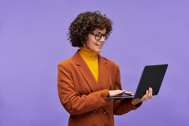 Jeune enseignant ou directeur général confiant utilisant un ordinateur portable